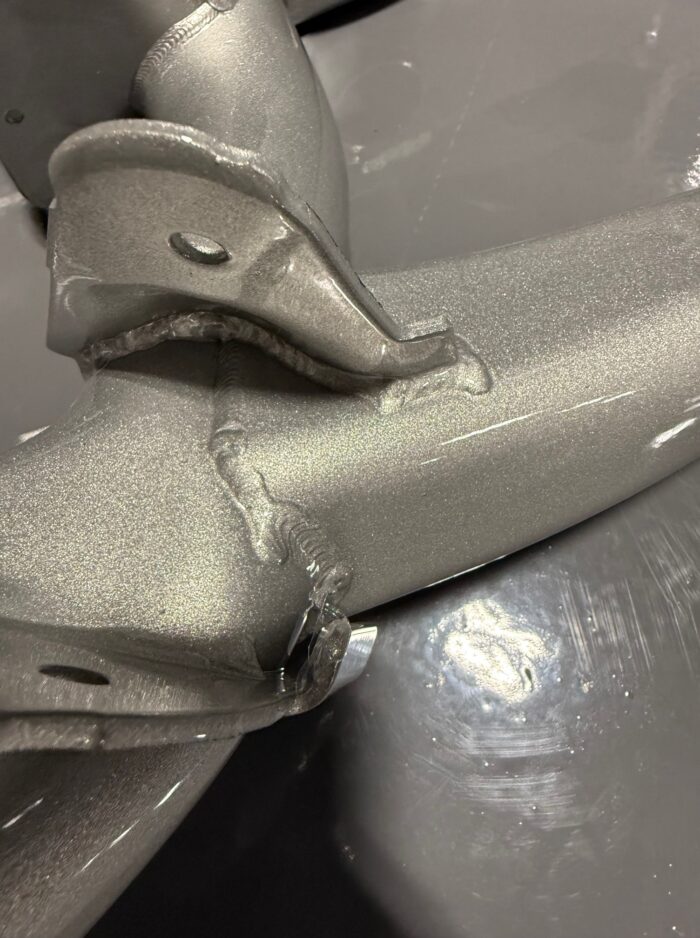 Close-up of reinforced factory welds on BMW E39 M5 rear subframe with silver powdercoat