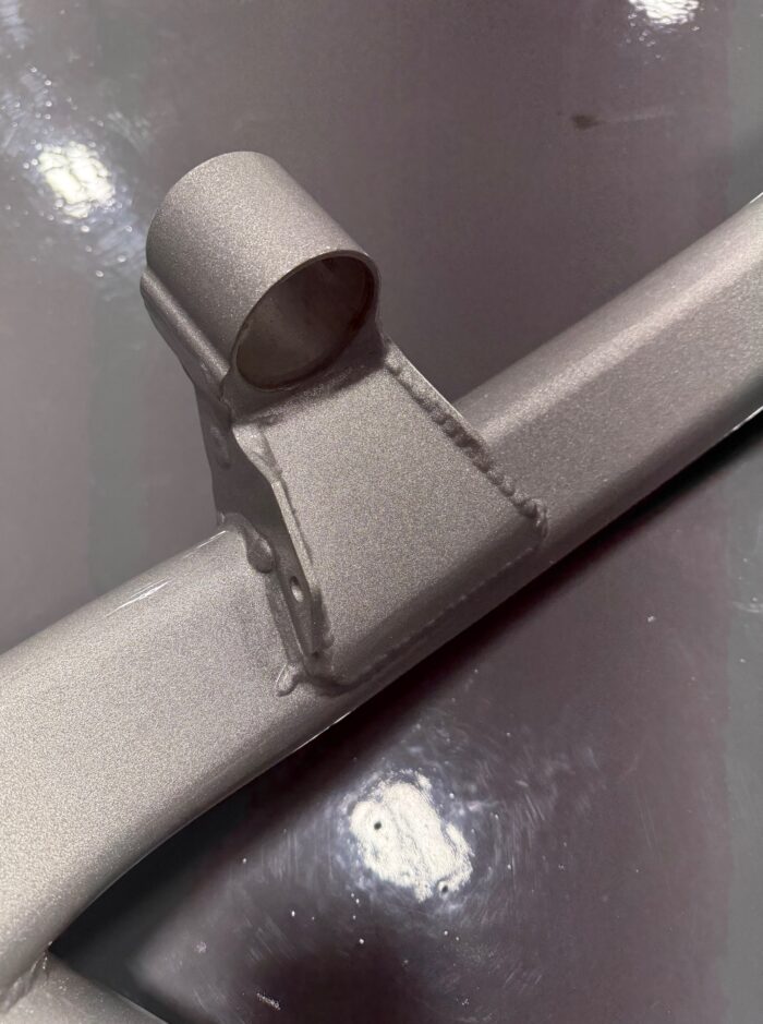 Reinforced front subframe tab on E39 M5 rear subframe with TIG welds and metallic silver powdercoat