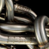 Close-up of S85 equal length headers with Partee Racing and Celeritech branding on TIG-welded stainless primary tubes